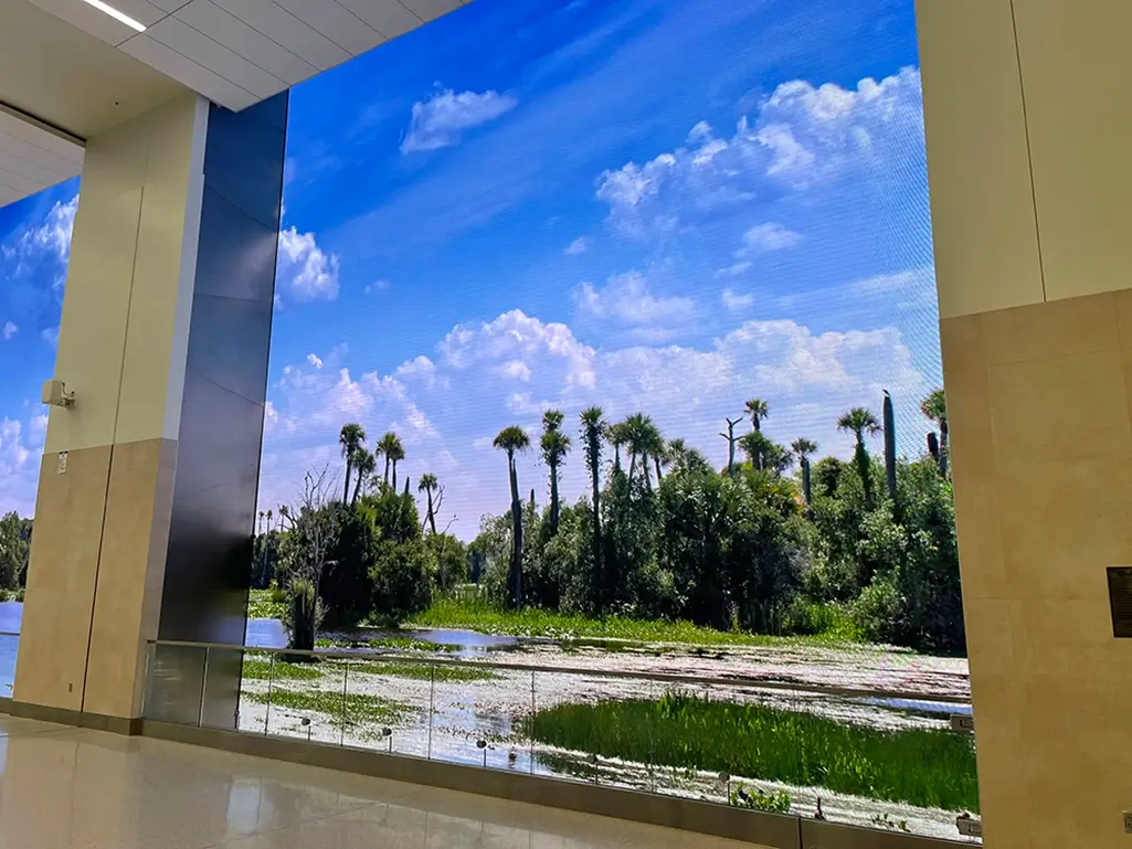 Windows on Orlando LED display showing a Florida wetland scene inside Orlando International Airport.