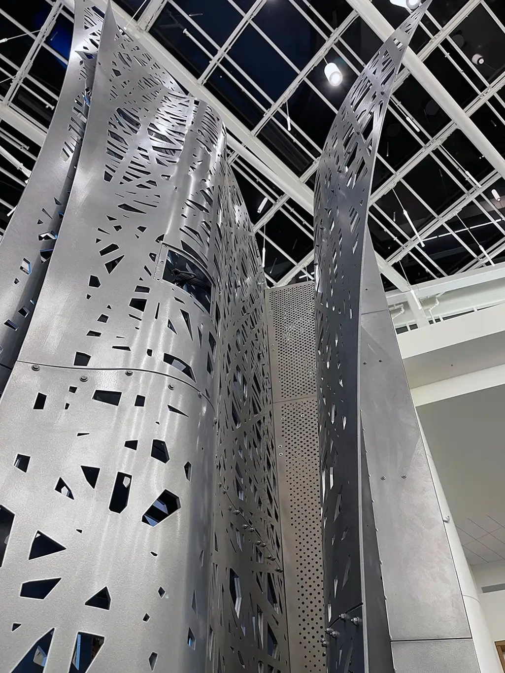 Close-up of the custom perforated metal framing and support structure for the Moment Vault LED installation.