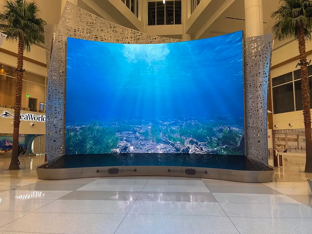 Moment Vault curved LED video wall displaying an underwater scene at Orlando International Airport.