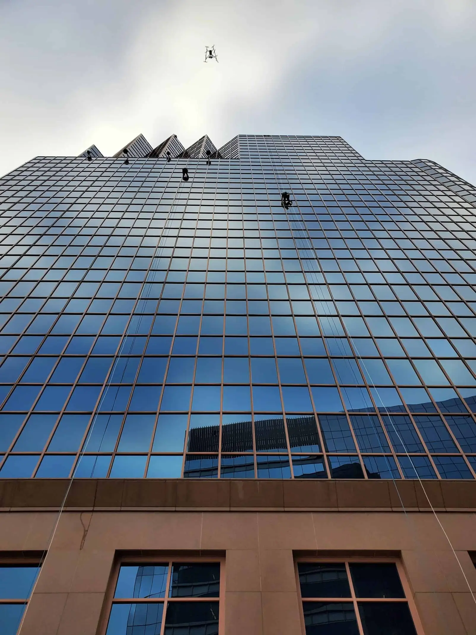 SPRAT-certified technicians perform a facade inspection on the glass exterior of a high-rise building.