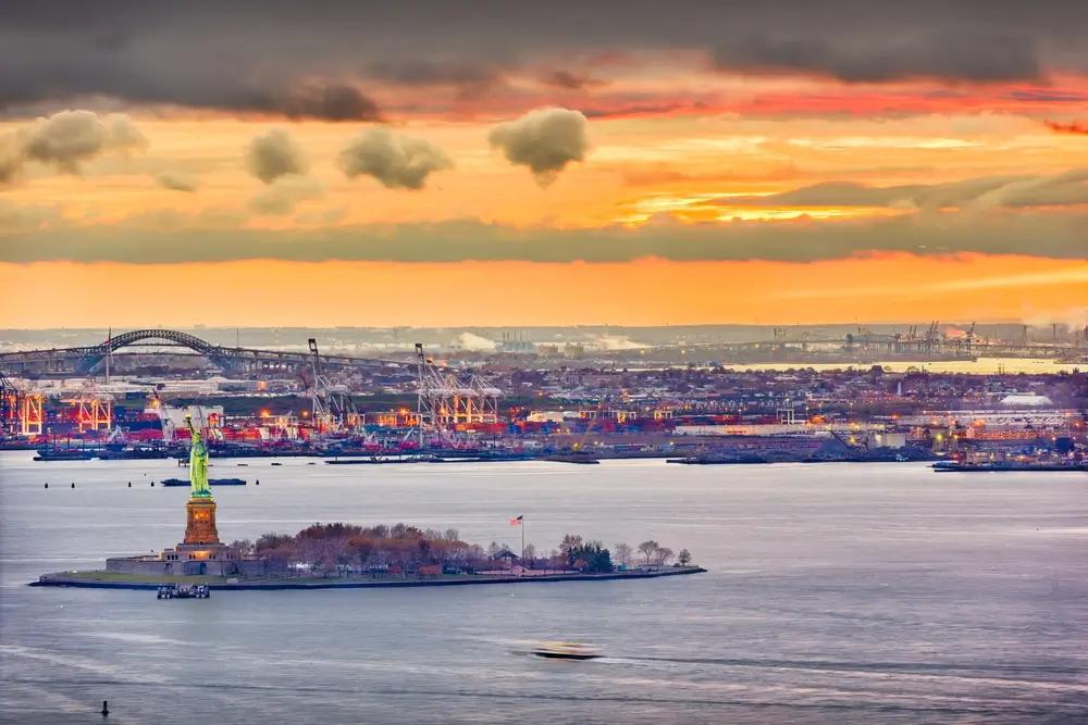 A sunset view of the Statue of Liberty, highlighting the importance of New York ports in sustainable maritime operations.