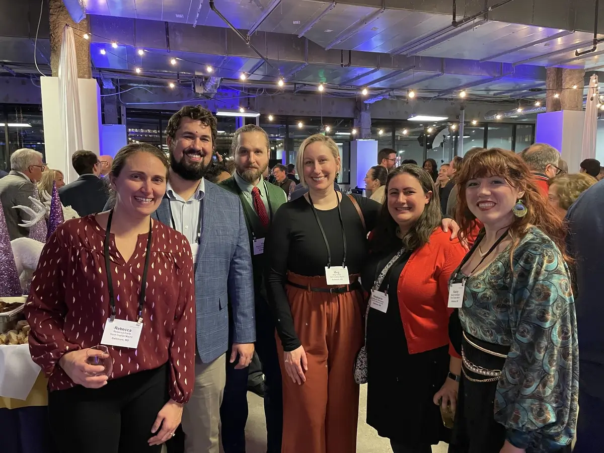 Stephanie Richmond and Brian Riggs smiling and posing with other industry professionals at the ULI Baltimore Holiday networking party.